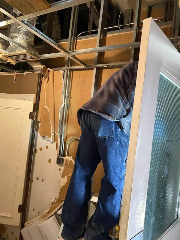 Person repairing interior wall, showcasing renovations